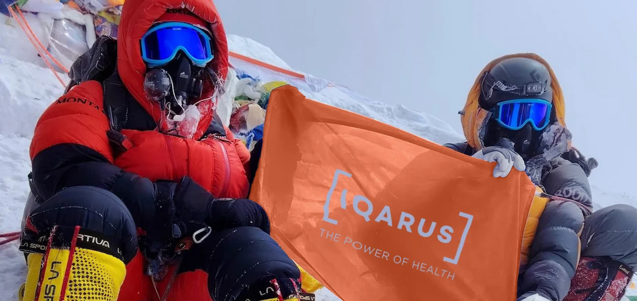 Icarus employees on a snowy hill holding their flag